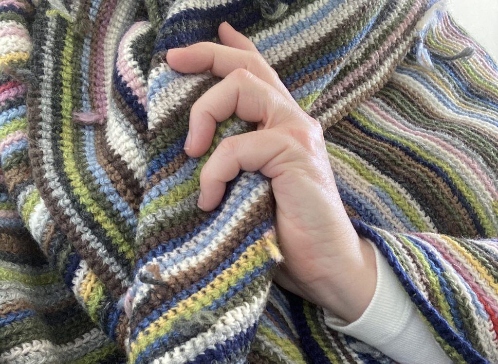 figure wrapped in a large crochet location dot